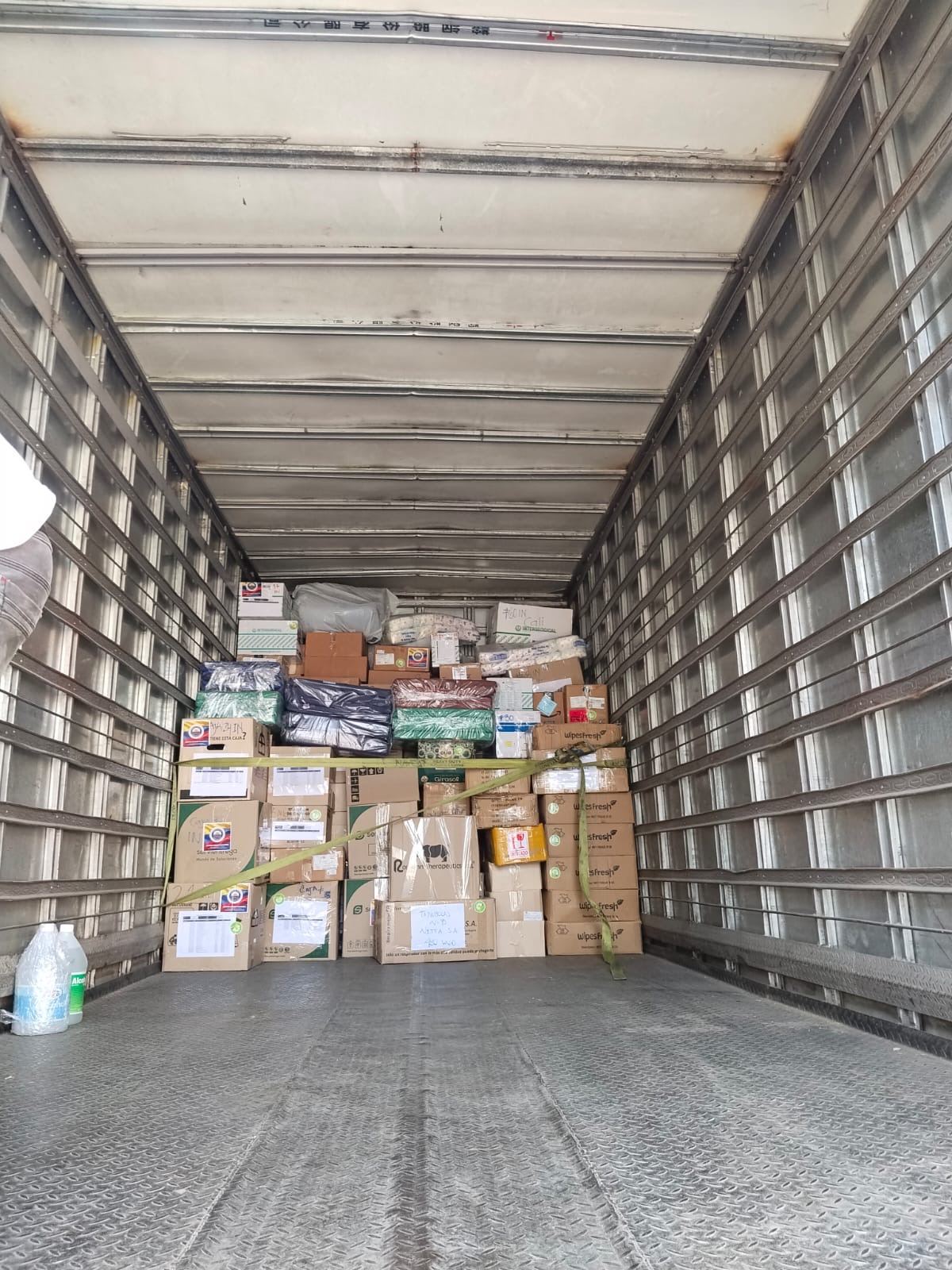 Interior de un camión cargado con cajas de donaciones aseguradas para el trayecto.