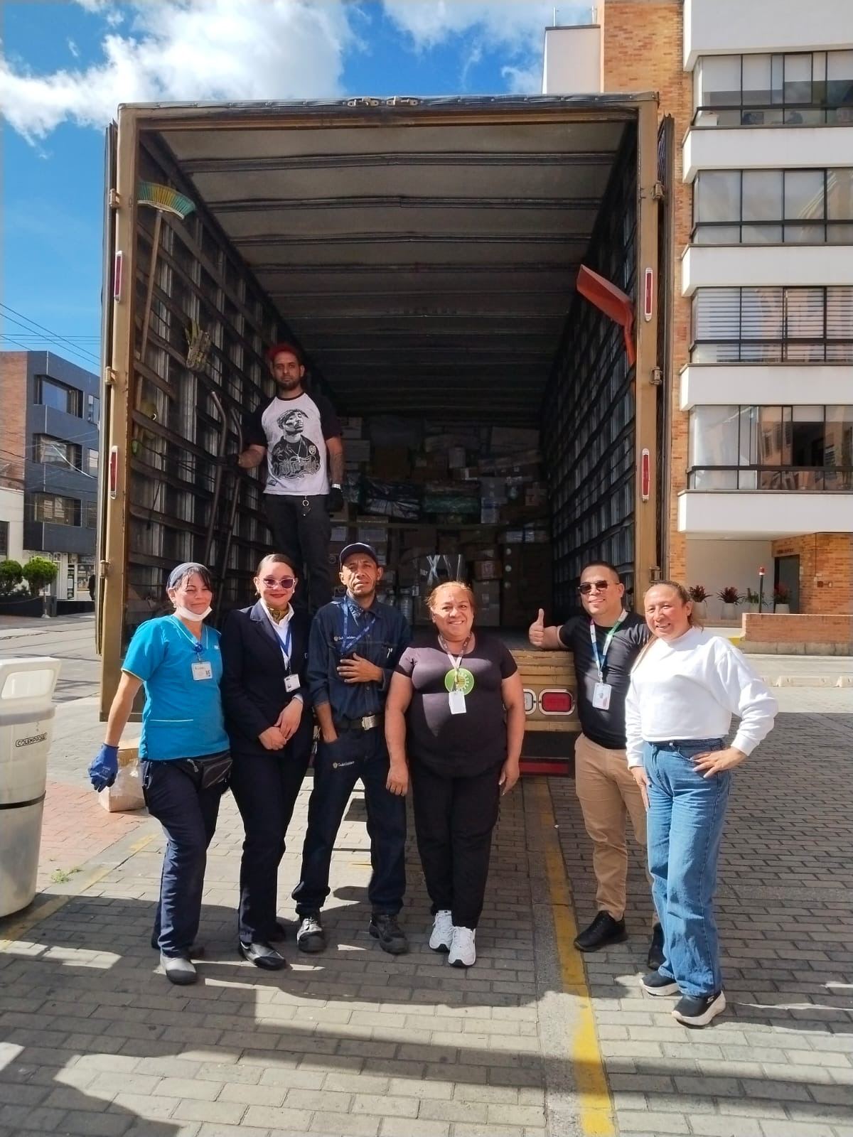 Grupo de voluntarios y personal de salud posando frente al camión de donaciones.
